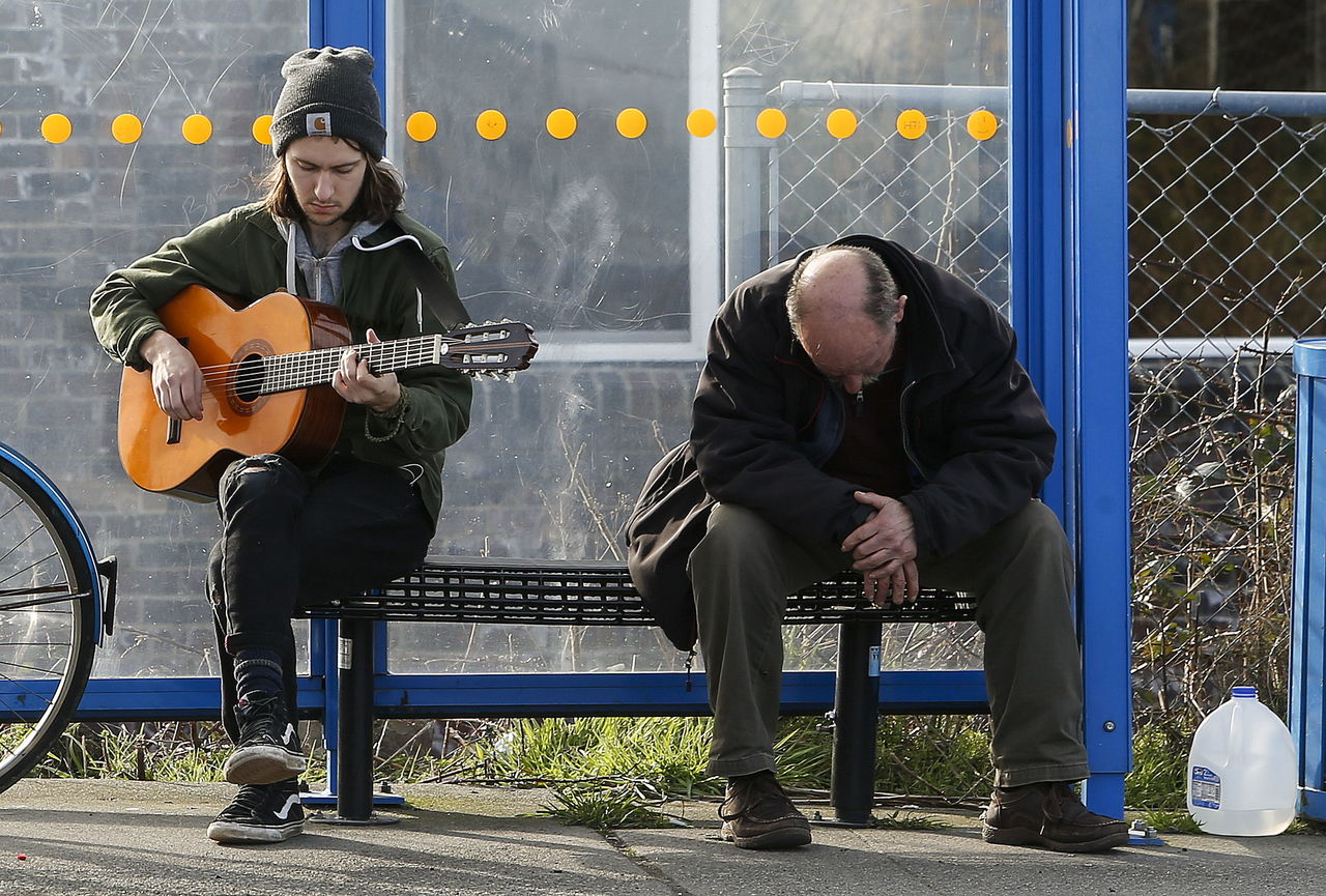 Zack Hoopengarner plays his guitar Tuesday while waiting for a bus near the Mukilteo ferry dock.