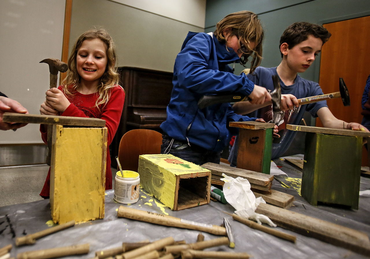 Sisters Elise Edinger, 9 (left), and Diana Edinger, 12, along with their brother, Griffin Eulenberg, 11, assemble and paint Mason Bee houses at a workshop held at the Snohomish Library, taught by Lisa Webb of Machias. Several adults, including parent volunteers, also helped out.