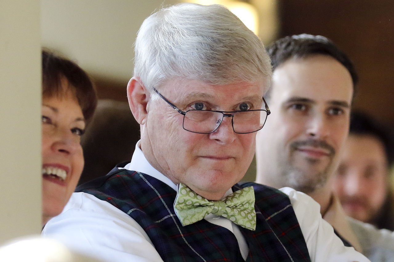 Claudia McClain, (L-R) Pat McClain and Tim McClain listen as guests recount stories of working with Pat over the years during his retirement party.