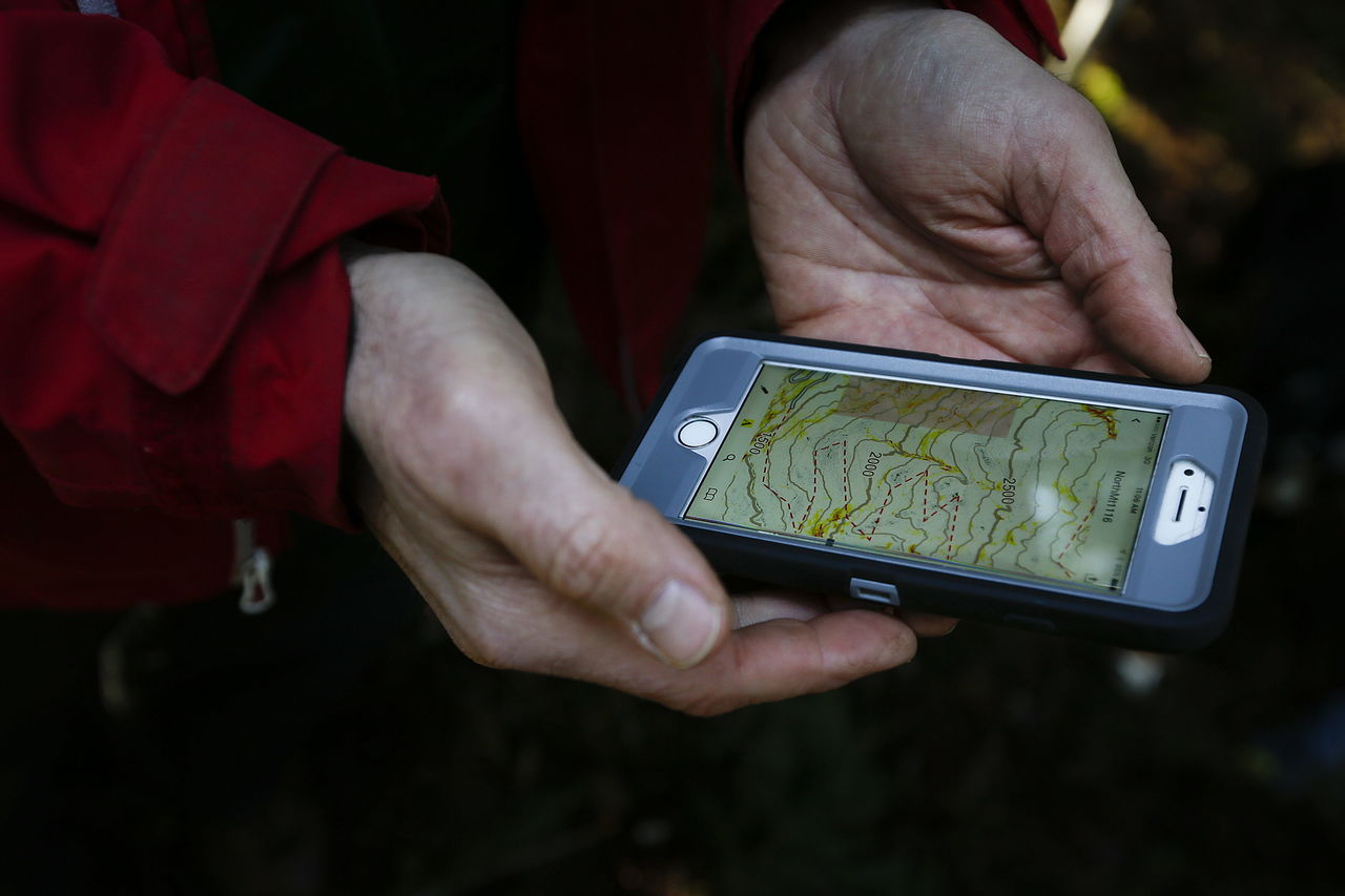 Evergreen Mountain Bike Alliance’s Mike Westra looks at a topographical map on his phone of the area along North Mountain Road in Darrington on Thursday. The area is slated to have 20 miles of new mountain bike trails built.