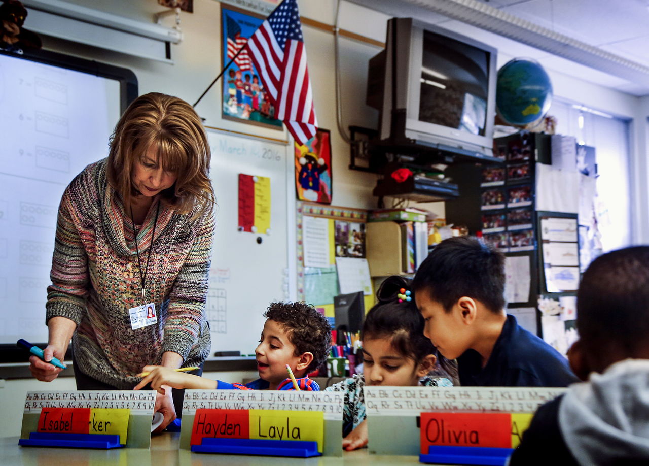 Kindergarten teacher Judi Rouse helps youngsters with lessons Thursday at Odyssey Elementary School.