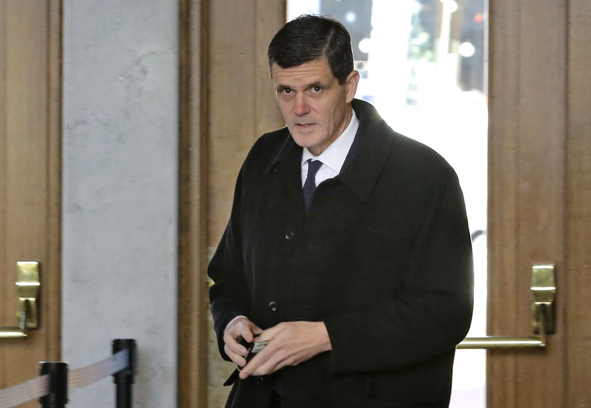 Washington state auditor Troy Kelley holds his wallet after showing his identification as he arrives for a federal court hearing, Tuesday, Dec.1, 2015, in Tacoma. Kelley was asking a judge to force the Justice Department to return $908,000 that was seized from Kelley after he was charged criminally with possession of more than $1 million in stolen money as well as money laundering.