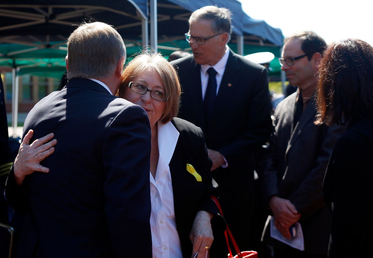 Arlington Mayor Barb Tolbert hugs Everett Mayor Ray Stephanson (left) after a ceremony with Washington State overnor Jay Inslee and Darrington Mayor Dan Rankin (background) in April 2014. Tolbert has placed the North Stillaguamish Valley Economic Redevelopment Plan in every office at Arlington City Hall. The brainstorming that started during a disaster has become her city’s road map.