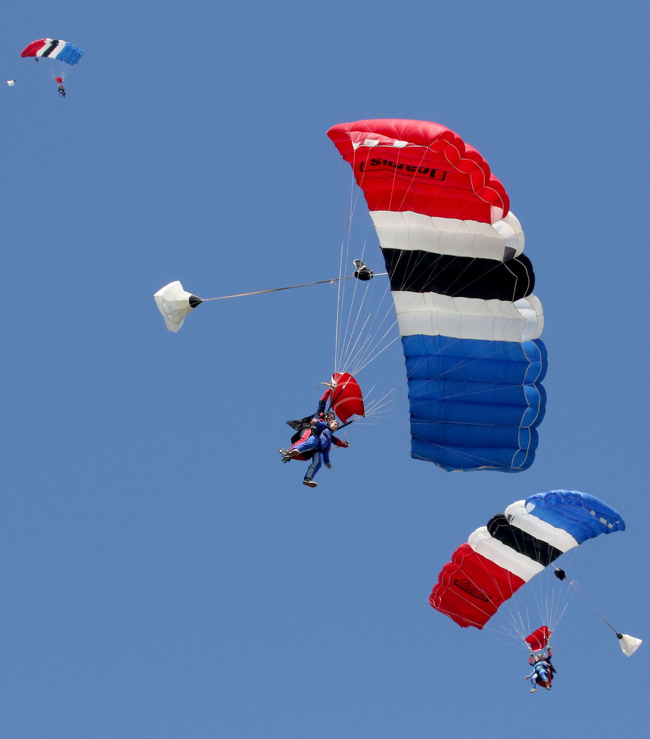 First-time skydivers and their tandem instructors circle in the air under parachutes after free-falling at Skydive Snohomish on Harvey Airfield on April 8 in Snohomish.