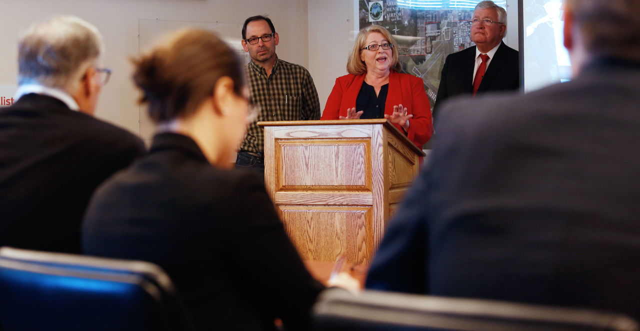 With two other judges, Gov. Jay Inslee (left) listens to Arlington Mayor Barbara Tolbert (center) as she, Darrington Mayor Dan Rankin and Bob Drewel (right), practice their pitch for the America’s Best Communities competition Thursday at the Arlington Airport.