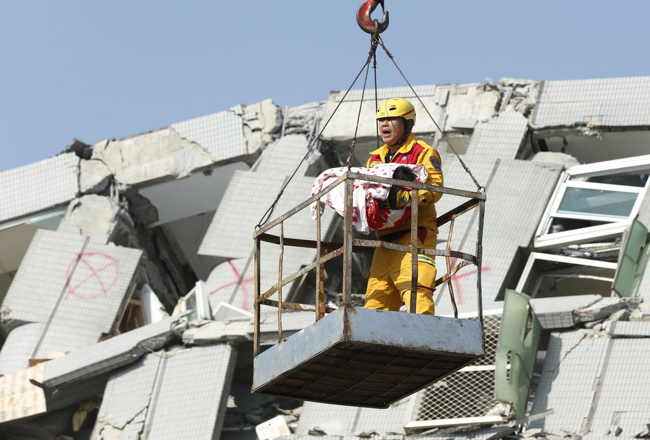 An emergency worker carries a rescued six month old baby girl from the rubble of a collapsed building in Tainan, Taiwan, on Sunday.