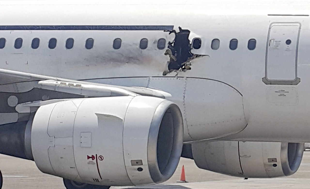 A hole is photographed Tuesday in a plane operated by Daallo Airlines as it sits on the runway of the airport in Mogadishu, Somalia. The gaping hole in the commercial airliner forced it to make an emergency landing at Mogadishu’s international airport late Tuesday, officials and witnesses said.