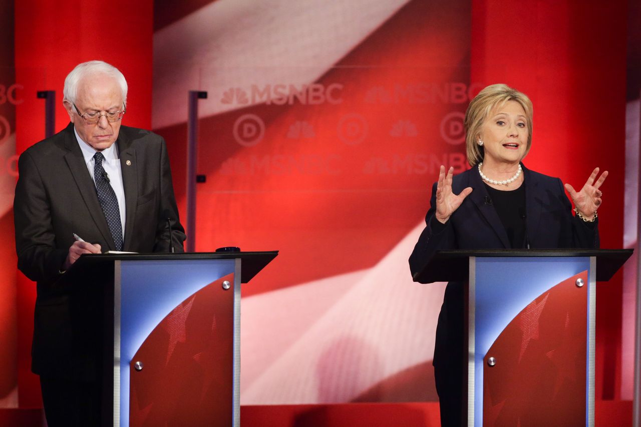 Democratic presidential candidate Hillary Clinton makes her opening statement as candidate Bernie Sanders takes notes during the Democratic presidential primary debate at the University of New Hampshire on Thursday.