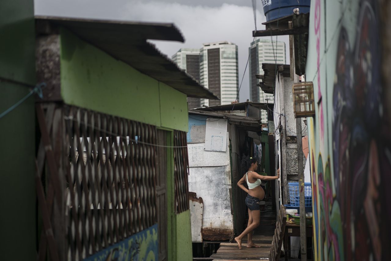 Tainara Lourenco, who is five months pregnant, stands outside her stilt home, built over a polluted body of water at a slum in Recife, Brazil, on Friday. To eke out a living for herself and her 2-year-old daughter, Lourenco ventures into a nearby swamp to hunt for crustaceans she hawks for $2.50 a kilo. “I think I got Zika or some other disease not long ago,” she said. “What can we do? Just hope that it doesn’t affect the baby.”
