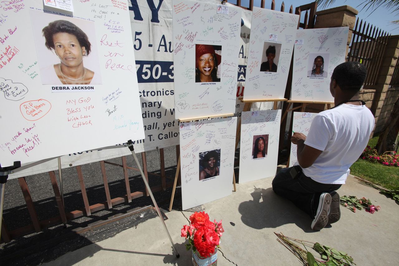 In this Aug. 10, 2010, photo, Irwin Webb helps with a memorial for victims of the “Grim Sleeper” serial killer, with photographs of the serial killer’s victims displayed in front of Bethel AME Church in South Los Angeles on the 25th anniversary of the first killing.