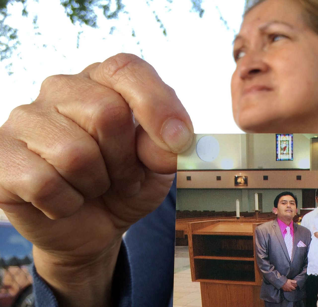 In This May 21, 2014, photo, Maria Sanchez holds a Jan. 29, 2012, photo of her neighbor Isidro Garcia at his daughter’s third birthday at a Bell Gardens, California, church, while talking to reporters in Bell Gardens.