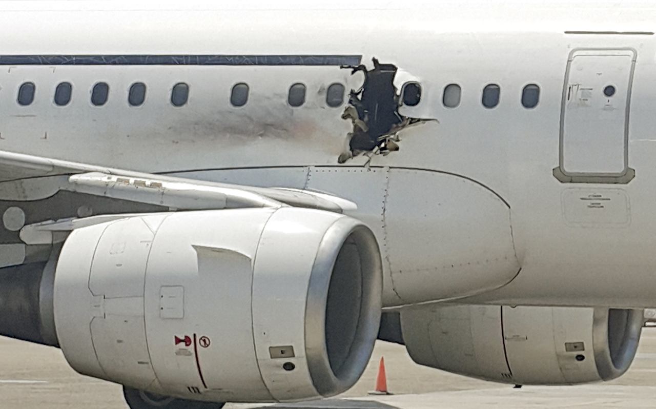 A hole is seen in a plane operated by Daallo Airlines as it sits on the runway of the airport in Mogadishu, Somalia, on Feb. 2.
