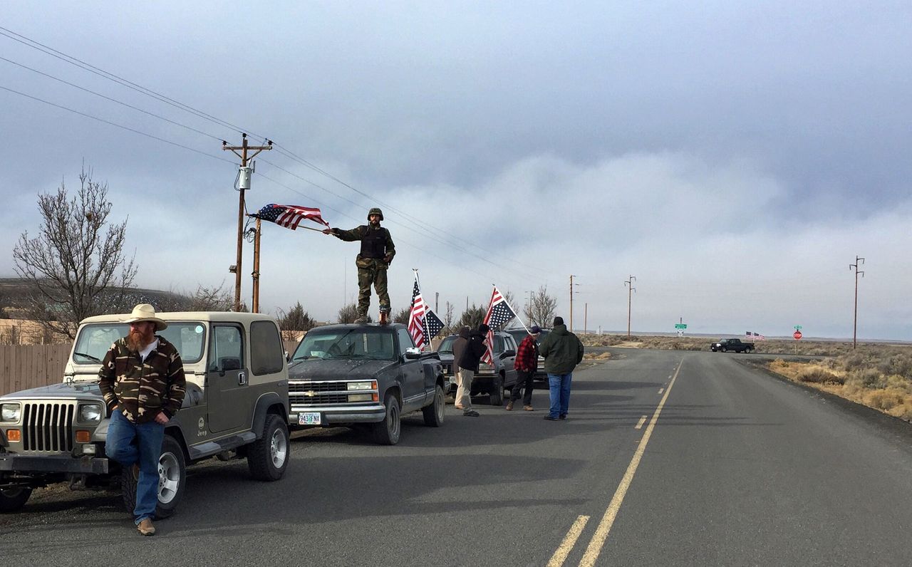 People wave American flags near the Malheur National Wildlife Refuge on Thursday near Burns, Oregon. The last four armed occupiers of the national wildlife refuge in eastern Oregon turned themselves in Thursday after law officers surrounded them in a tense standoff.