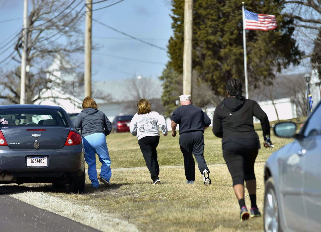 Parents run to see if they are allowed to pick up their kids at Madison Local Schools on Monday in Madison Township in Butler County, Ohio, after a school shooting.