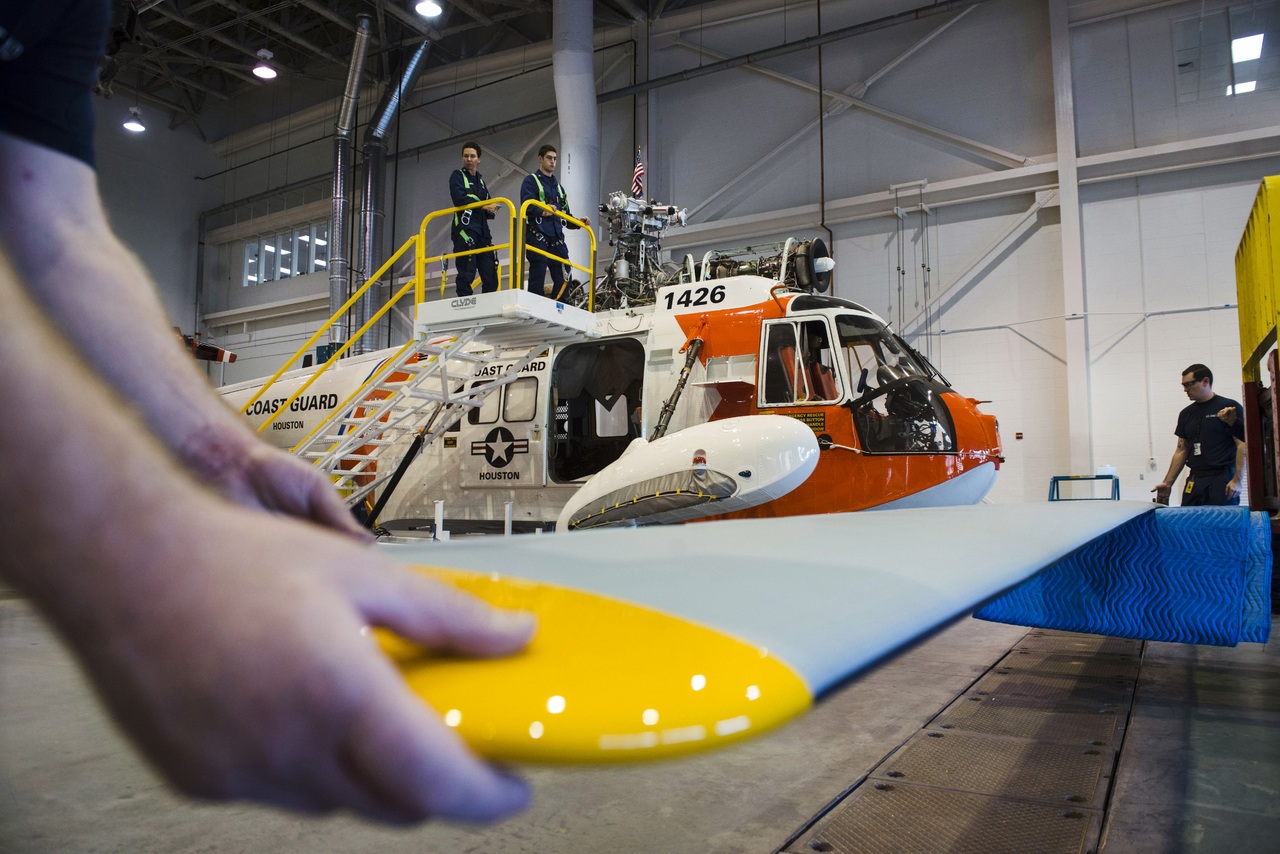 Coast Guard service members prepare to attach a blade to a Coast Guard Sikorsky HH-52A while working to reassemble the helicopter in the Smithsonian’s conservation lab in February in Chantilly, Virginia.