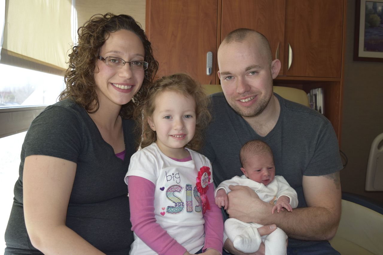 Chad and Melissa Croff pose with their newborn, Evelyn Joy, and Eliana Adaya at Henry Ford Macomb Hospital in Clinton Township, Michigan, on Feb. 29.