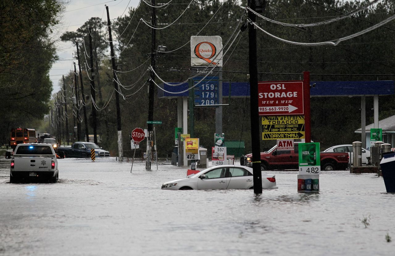 Vehicles are submerged in flowing water Friday in Hammond, Louisiana.