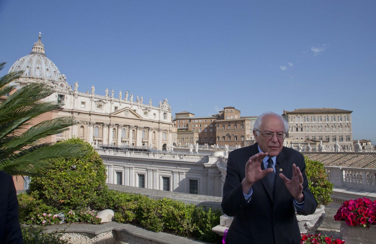 Presidential candidate Bernie Sanders, backdropped by St. Peter’s Basilica, talks with reporters at the Vatican on Saturday.
