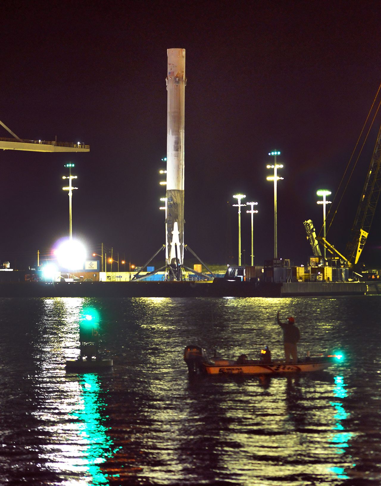 A boater watches as a SpaceX Falcon 9 booster returns to Port Canaveral, Florida, on Tuesday.