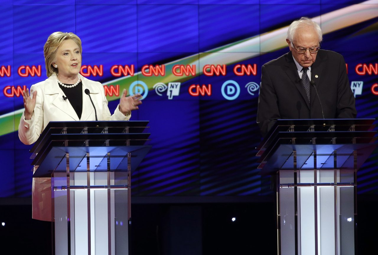 Bernie Sanders takes notes as Hillary Clinton speaks during the CNN Democratic Presidential Primary Debate at the Brooklyn Navy Yard on Thursday.