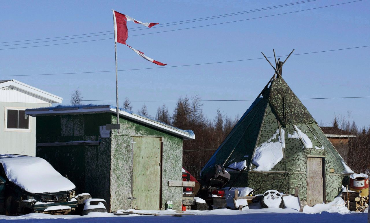 In this Nov. 29, 2011 photo, a tattered Canadian flag flies over a building in Attawapiskat, Ontario, Canada. The country’s Parliament agreed Tuesday to hold an emergency debate on a suicide crisis in the remote aboriginal community after 11 people, nine of them minors, attempted suicide over the weekend and more than a dozen youths were overheard making a suicide pact.