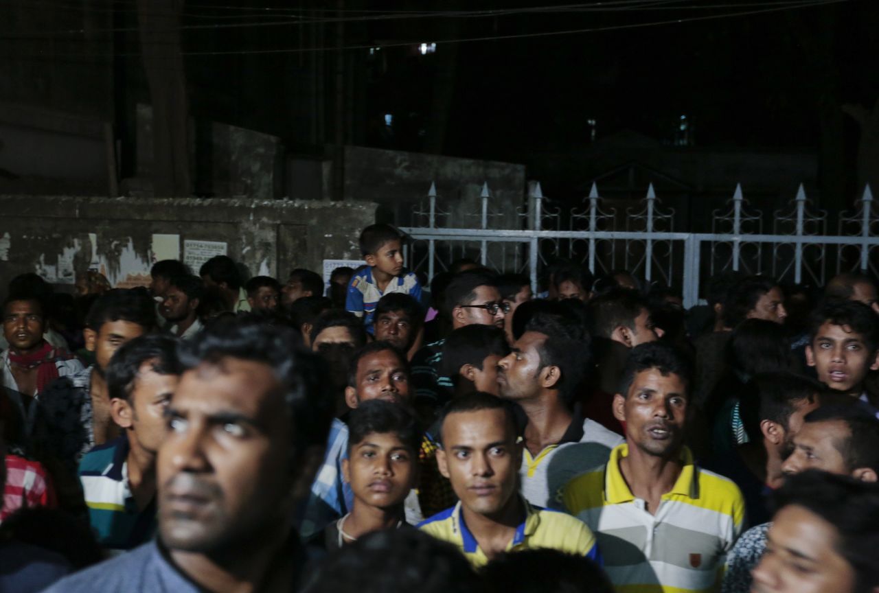 Bangladeshi people gather outside a building where two people were found stabbed to death in Dhaka, Bangladesh, on Monday.