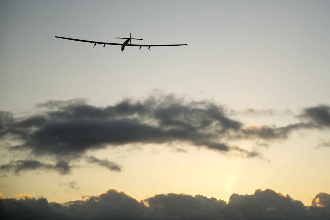 The Solar Impulse 2 solar plane flies into the sunrise out of Kalaeloa Airport on Thursday in Kapolei, Hawaii. The solar plane will fly a two-and-a-half day journey to Northern California.