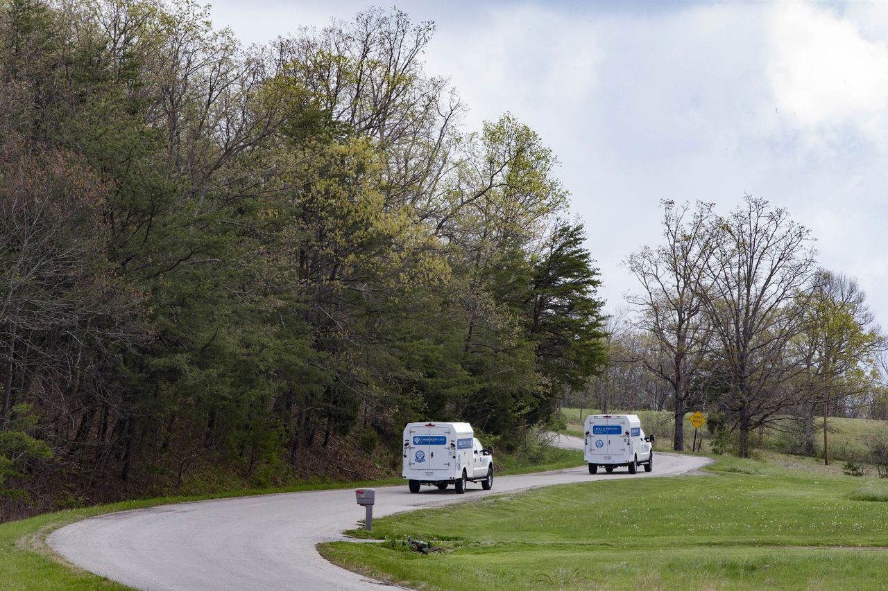 Crime scene investigation vehicles drive up Union Hill Road as they approach the location of a reported multiple shooting Friday in Pike County, Ohio.