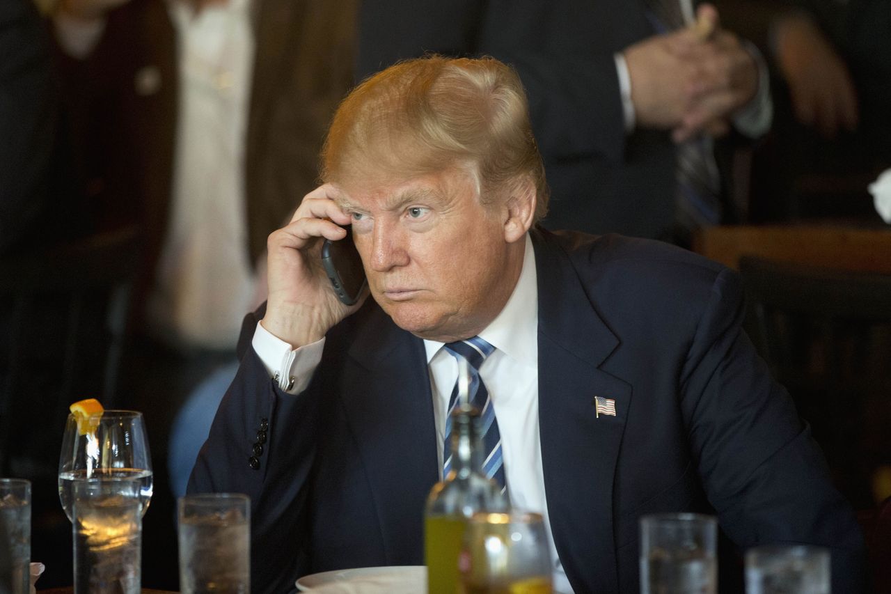 In this Feb. 18 photo, Republican presidential candidate Donald Trump listens to his mobile phone during a lunch stop in North Charleston, South Carolina.