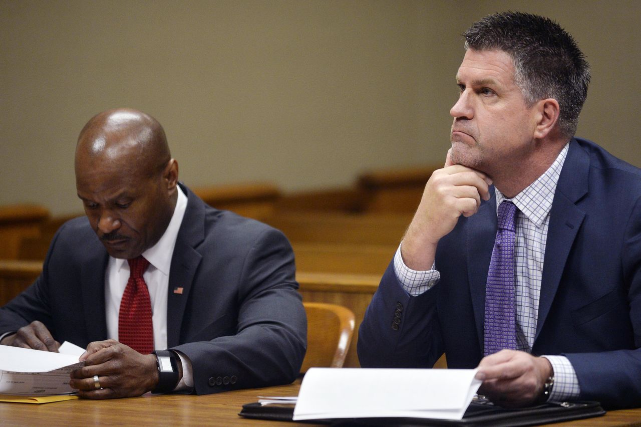 Ellis Stafford (left) and Jeff Seipenko, Special Agent at State of Michigan Attorney General, sit in court with warrants in their hands Wednesday at the Floyd J. McCree Courts & Human Services Center in Flint, Michigan. Two state regulators and a Flint employee were charged Wednesday with evidence tampering and several other felony and misdemeanor counts related to the Michigan city’s lead-tainted water crisis.