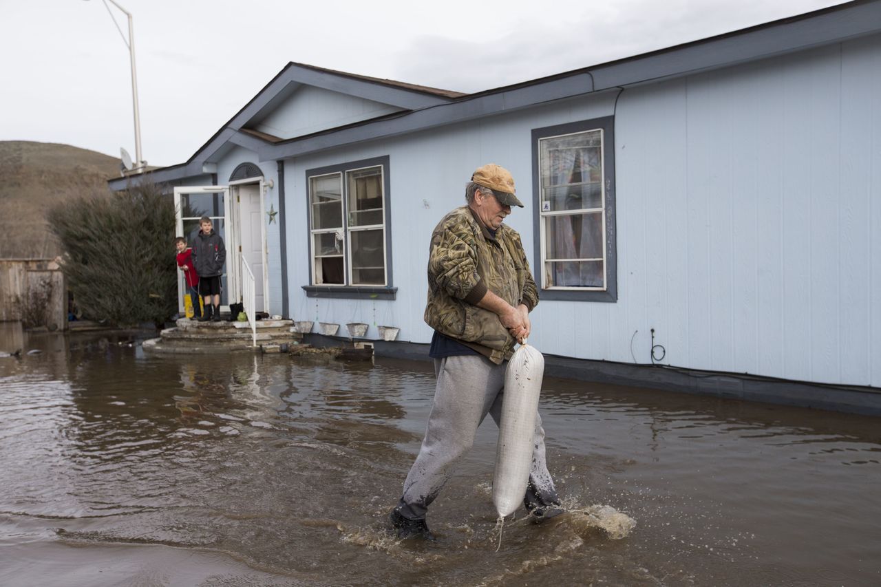 Greg Brown tries to block his nephew’s driveway with sandbags Monday in the Riverview Manor neighborhood of Yakima. A President’s Day storm brought record rainfall to the Pacific Northwest and sent rivers overflowing their banks Tuesday.