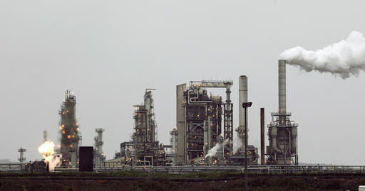 FILE - This April 2, 2010, file photo, shows a Tesoro Corp. refinery, including a gas flare flame that is part normal plant operations, in Anacortes, Wash. The plant is among those likely to be affected if Washington state becomes the first in the nation to pass a tax on carbon pollution from fossil fuels such as coal, gasoline and natural gas. (AP Photo/Ted S. Warren, File)