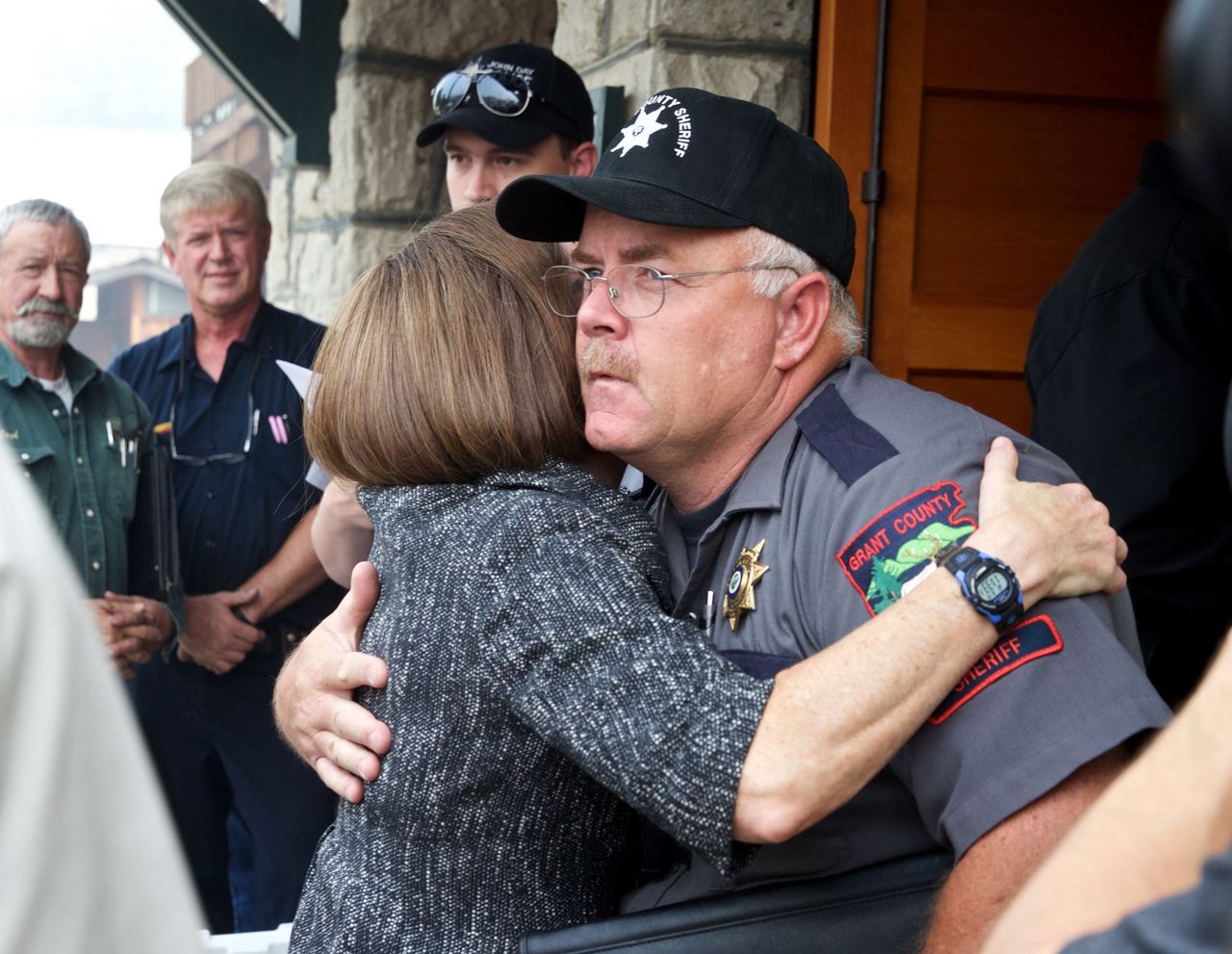 In this Aug. 19, 2015, photo, Oregon Gov. Kate Brown hugs Grant County Sheriff Glenn Palmer as they enter a meeting with homeowners in Canyon City, Oregon. The Oregon agency that licenses police officers has asked the state attorney general’s office to investigate complaints about Palmer, who met with some of the armed occupiers who seized a national wildlife preserve.