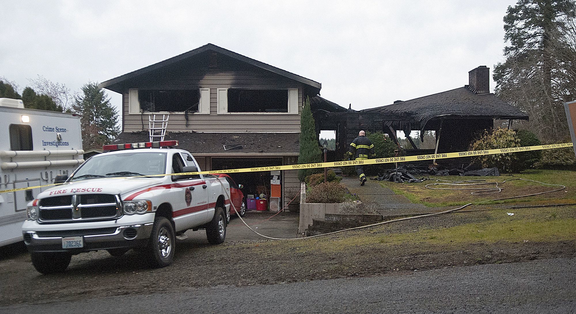 A fireman walks to the scene of a house fire where three children perished Friday in Centralia.