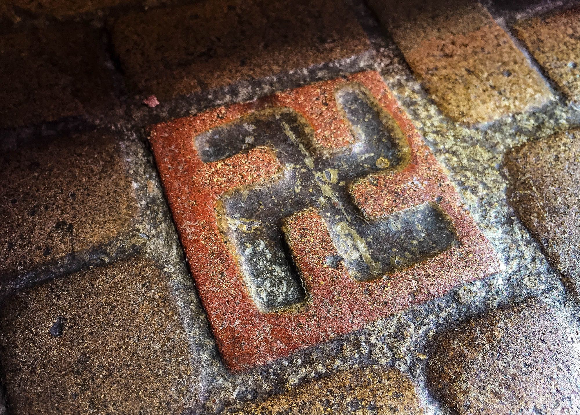 This March 3 photo shows one of about 60 floor tiles emblazoned with swastika-style crosses in the entrance to the Longview Community Church in Longview. The symbol was once seen as a sign of good fortune, but is now more closely associated with terror.