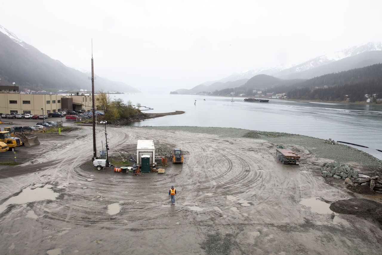 A city worker walks along a site Wednesday that will soon host a life-sized whale sculpture and bridge park project along the Gastineau Channel in Juneau, Alaska. The city is being sued by a industry representative for 12 cruise lines which alleges that the city is misspending funds from a per-passenger tax on the whale project and others which do not directly benefit cruise passengers.