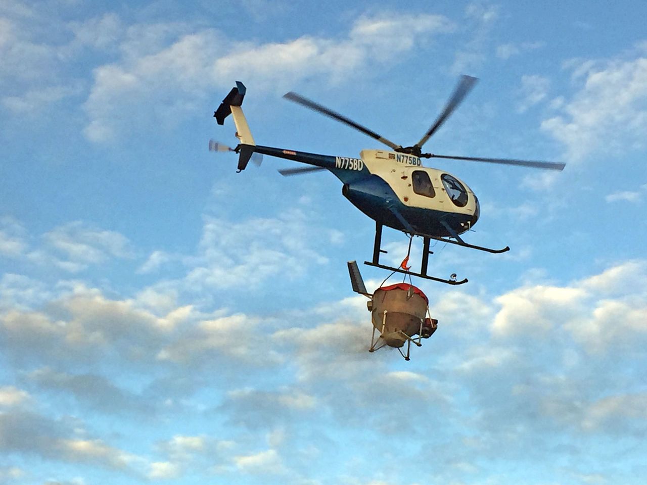 A helicopter carries seeds to be dispersed over a burned area of the Soda Fire in southwest Idaho in 2015 to help stabilize soils and combat invasive weeds such as cheatgrass.