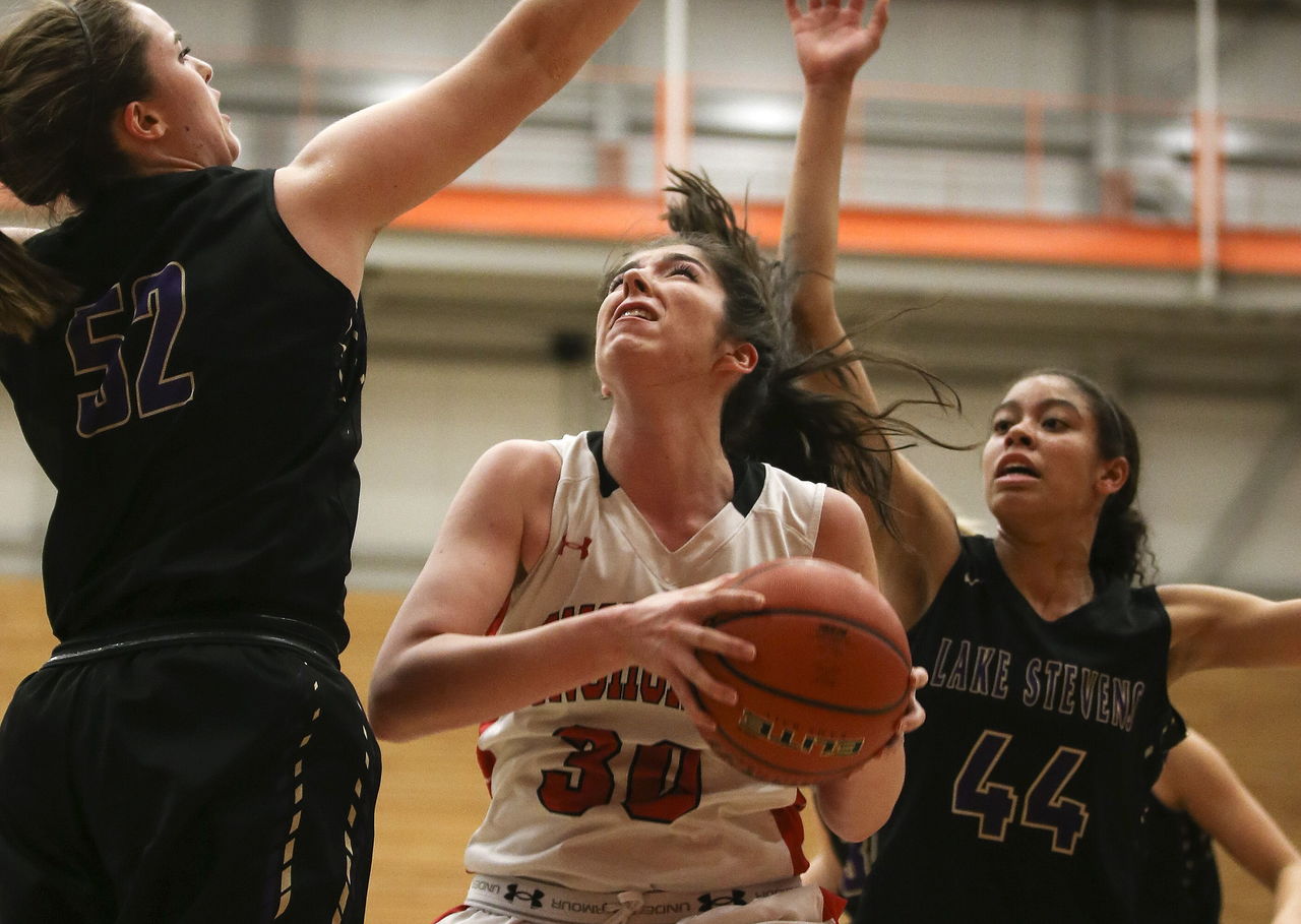 Snohomish’s Madeline Smith goes up for a shot with Lake Stevens’ Hailey Wilson (left) and Kylee Griffen defending during the 4A District 1 championship game Thursday night at Everett Community College. Snohomish won 56-26.