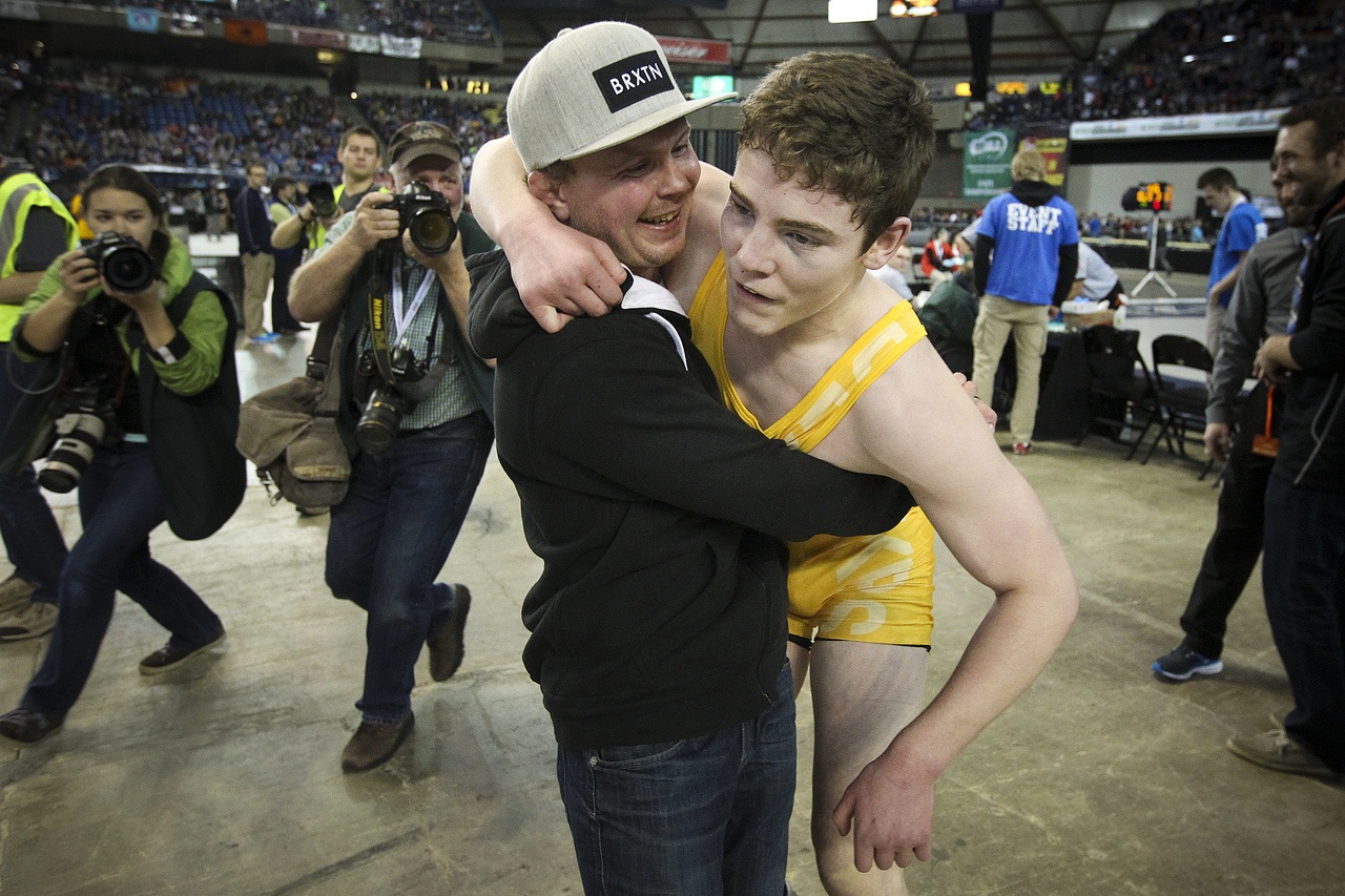 Lake Stevens wrestling alum Burke Barnes congratulates the Vikings’ Michael Soler (right) on his fourth state title during Mat Classic on Saturday.