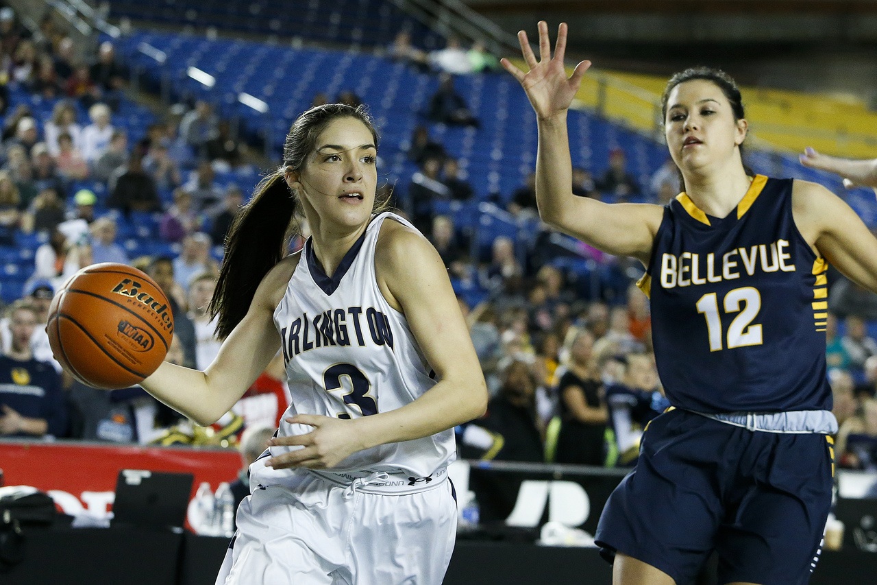 Arlington’s Gracie Castaneda (drives to the basket as Bellevue’s Tatiana Streun tries to defend during the first period of the Class 3A girls state championship game on Saturday night.