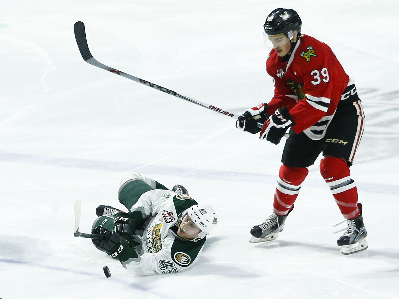 The Silvertips’ Connor Dewar (left) slides across the ice as Portland’s Colton Veloso (right) pursues the play during a game Wednesday at Xfinity Arena in Everett.