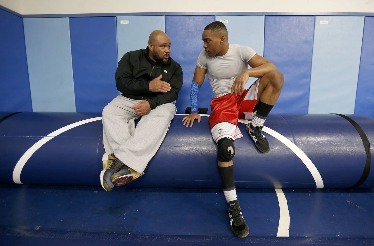 Sultan wrestler Jamell Carroll II listens to his father Jamell Carroll, Sr., an assistant coach, during practice Tuesday at Sultan High School.