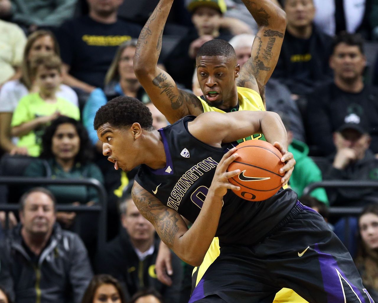 Washington’s Marquese Chriss (foreground) battles Oregon’s Elgin Cook for position under the basket during the first half of a game Sunday in Eugene, Ore.