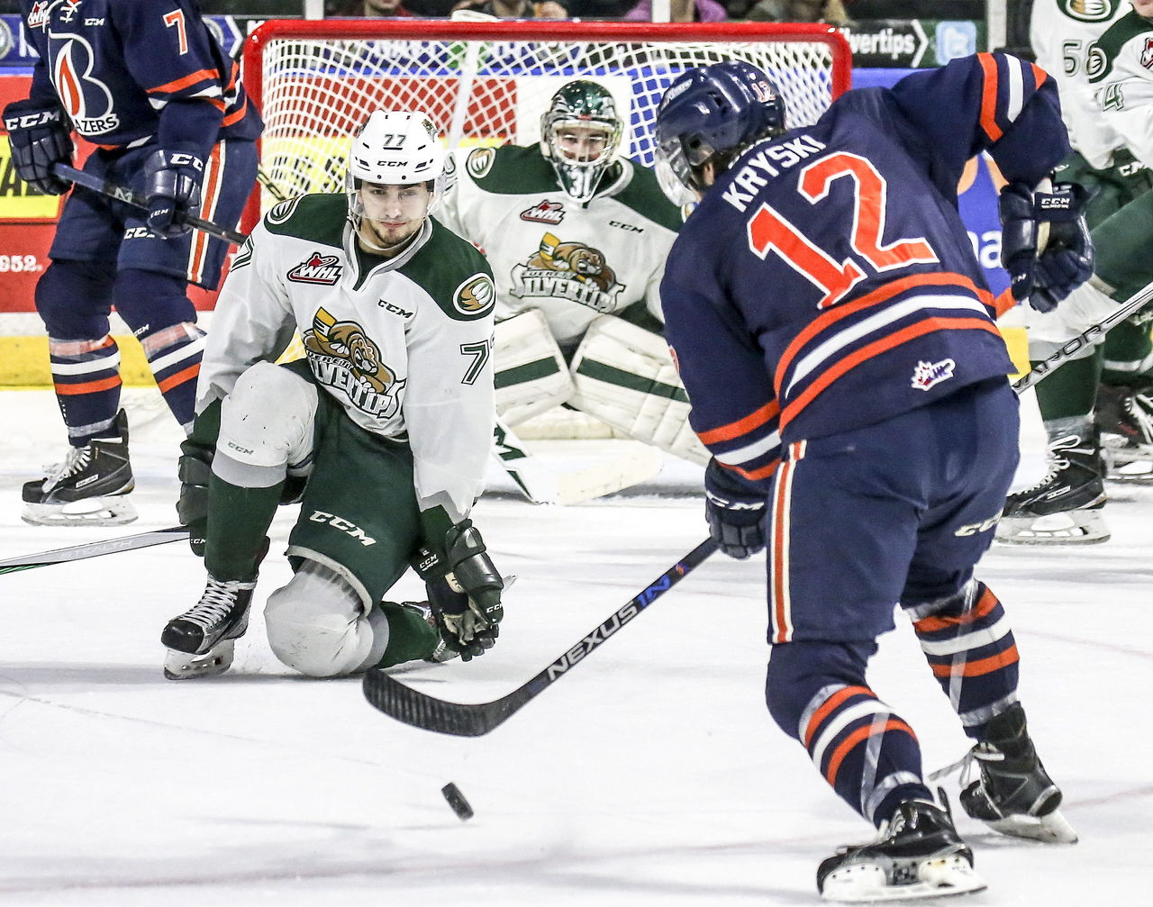 The Blazers’ Jake Kryski works the puck with the Silvertips’ Yan Khomenko defending during a game Friday night at Xfinity Arena in Everett.