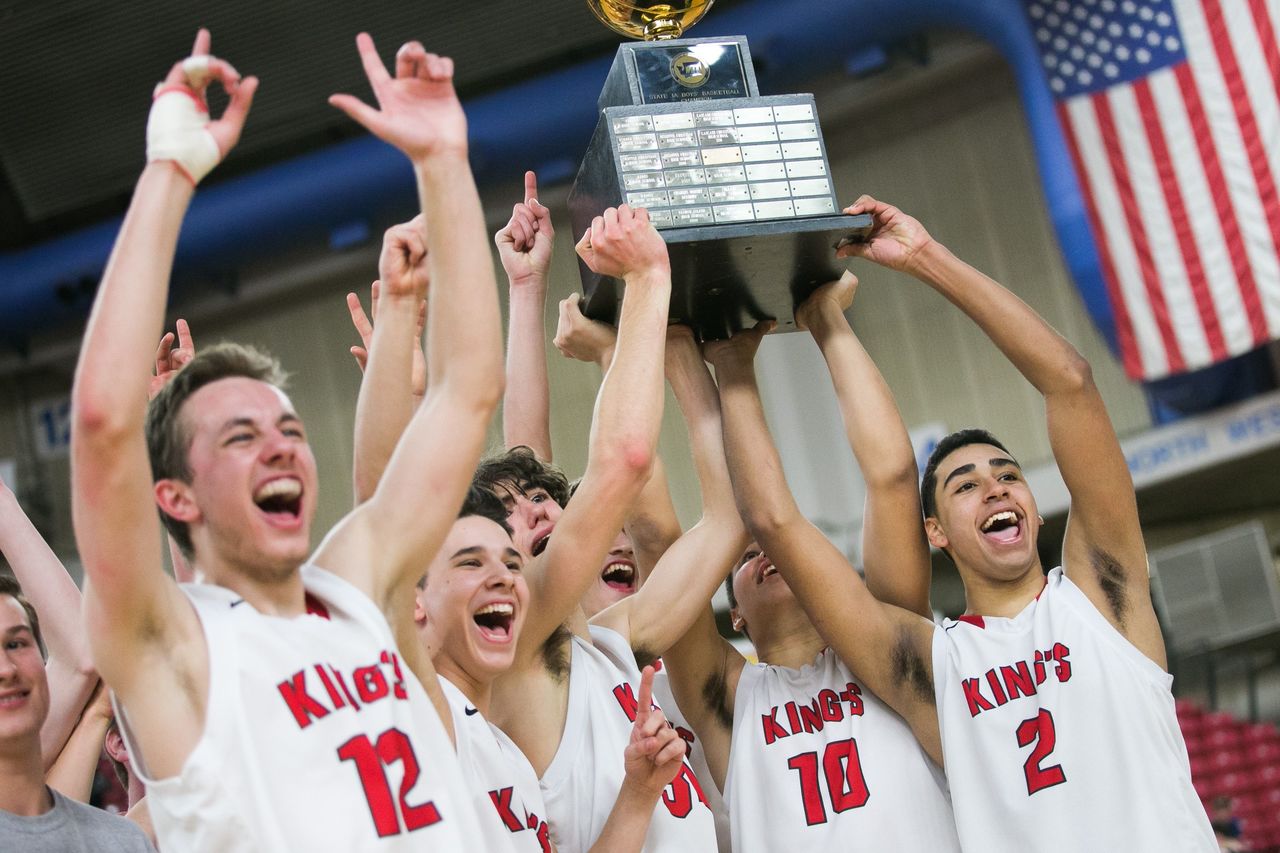King’s players hold up their Class 1A championship trophy at the state basketball tournament in Yakima.