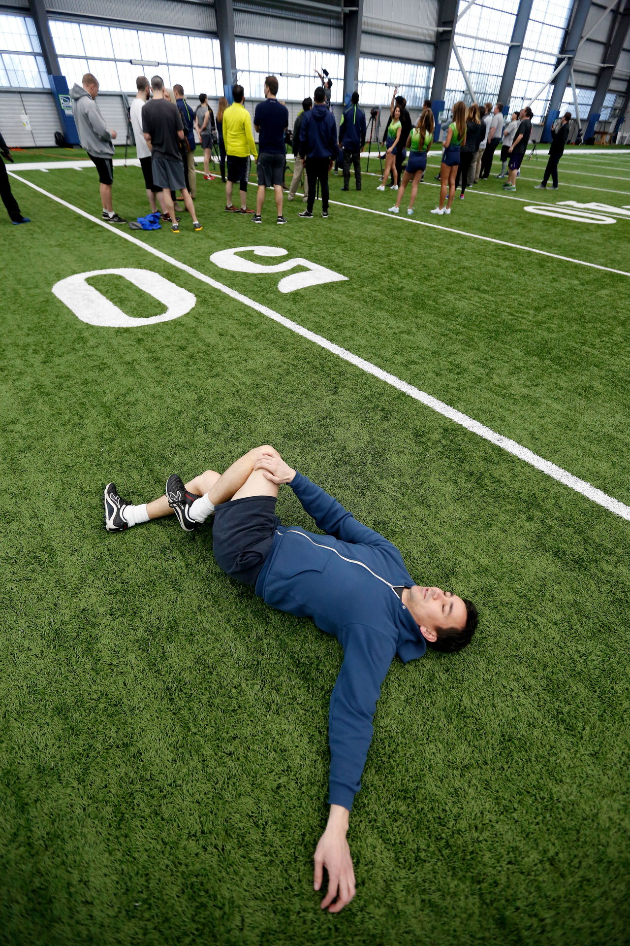 Herald sports writer Nick Patterson stretches after injuring his back at the media combine held at the Seattle Seahawks’ Virginia Mason Athletic Center on Feb. 29.
