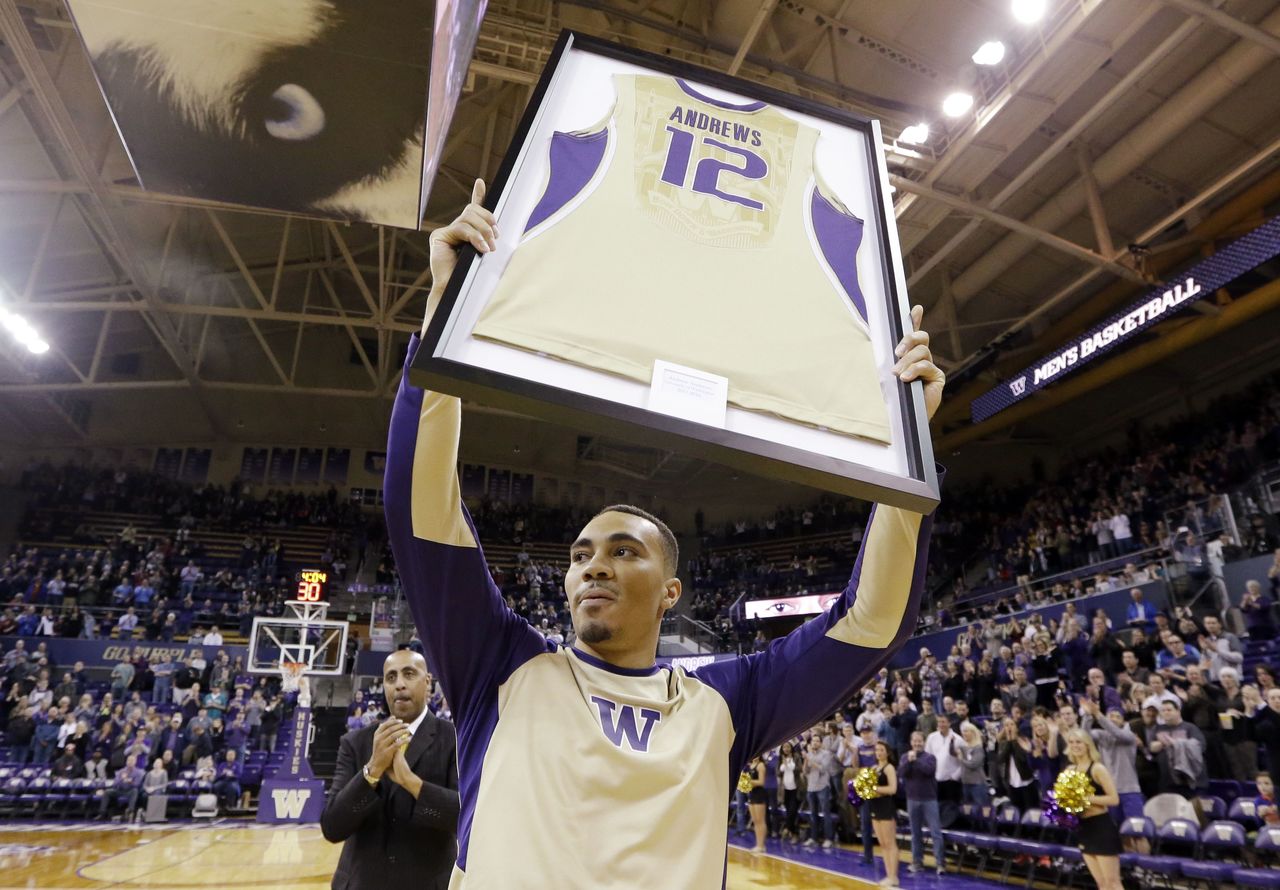 Washington’s Andrew Andrews holds up a replica of his jersey as he is honored during senior night before Wednesday’s game against Washington State.