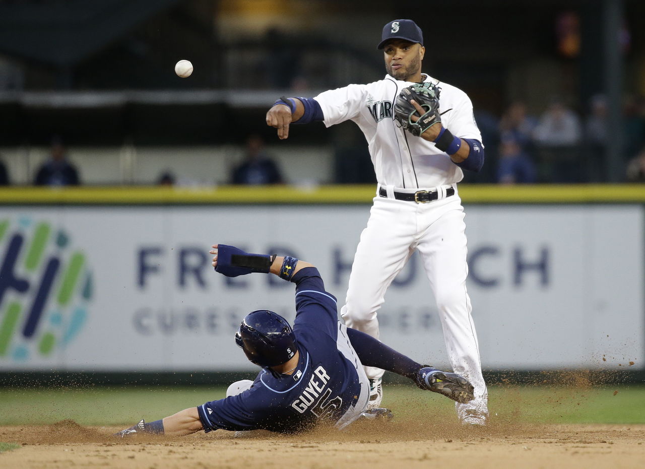 The Mariners’ Robinson Cano throws to first as the Rays’ Brandon Guyer attempts to break up the double play during a game last season.