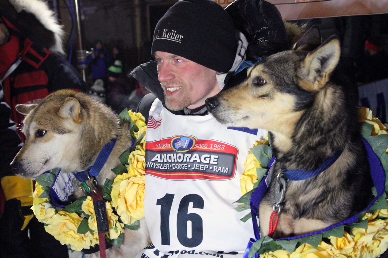 Dallas Seavey poses with his lead dogs Reef (left) and Tide after finishing the Iditarod Trail Sled Dog Race early Tuesday in Nome, Alaska.