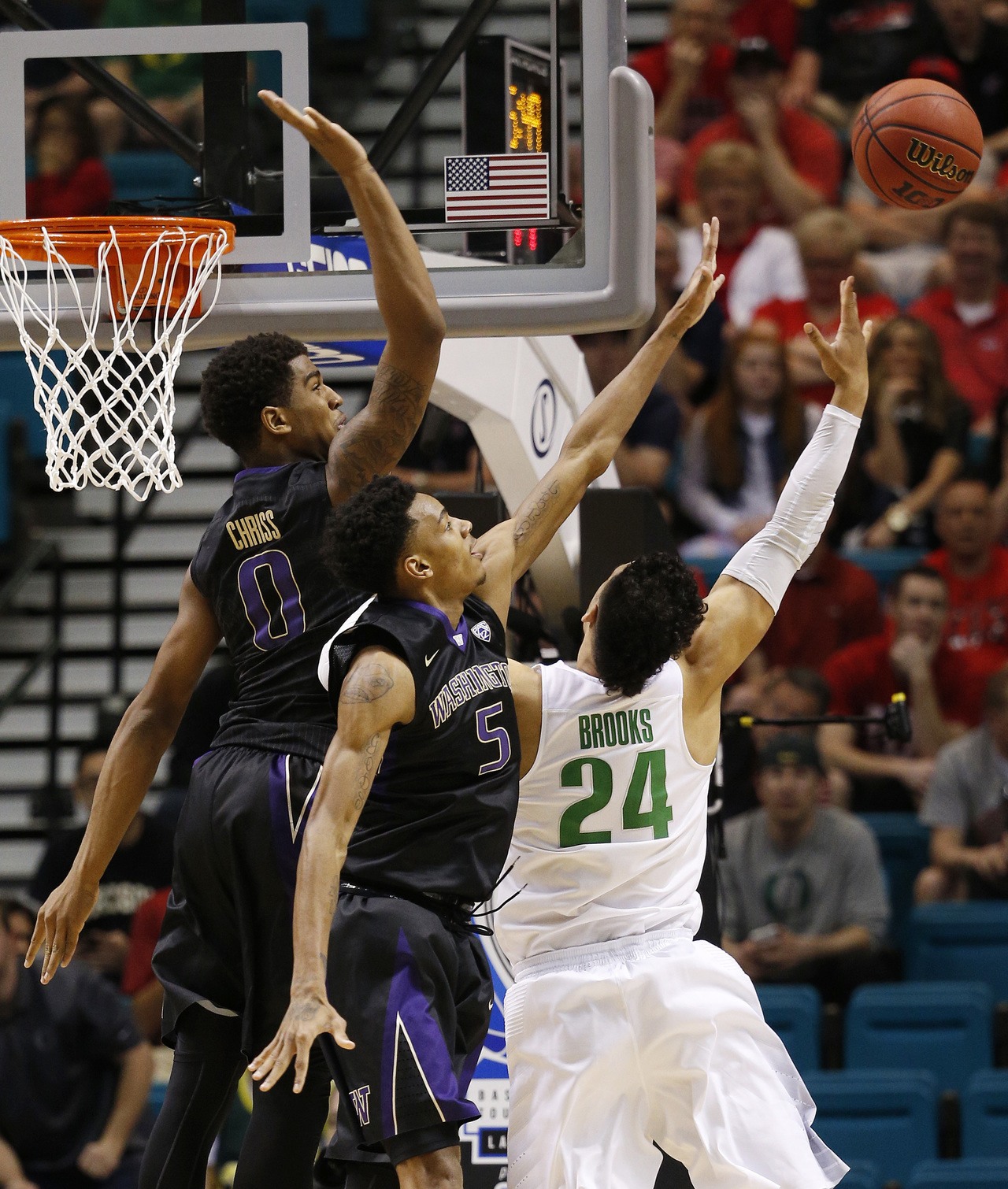 Oregon forward Dillon Brooks (right) shoots against Washington guard Dejounte Murray (5) and Washington forward Marquese Chriss (0) during the first half of a game in the quarterfinal round of the Pac-12 men’s tournament on Thursday in Las Vegas.